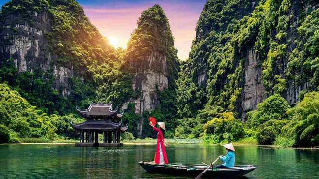 Sampan boats beneath limestone cliffs at Trang An, Ninh Binh